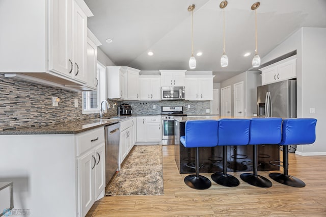 kitchen featuring white cabinetry, sink, stainless steel appliances, and vaulted ceiling