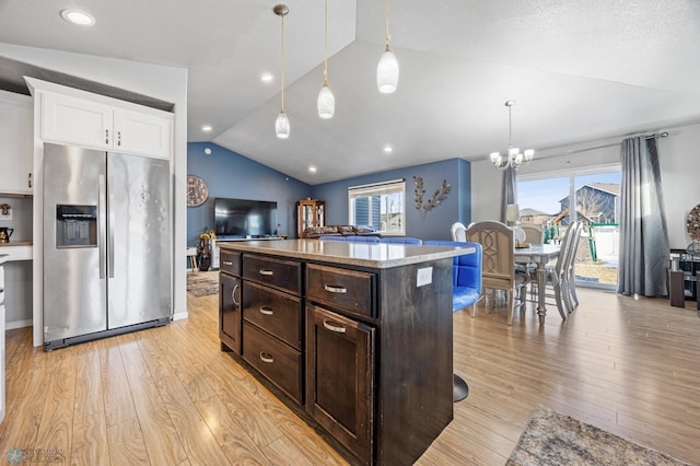 kitchen featuring hanging light fixtures, stainless steel fridge with ice dispenser, light hardwood / wood-style floors, vaulted ceiling, and dark brown cabinets