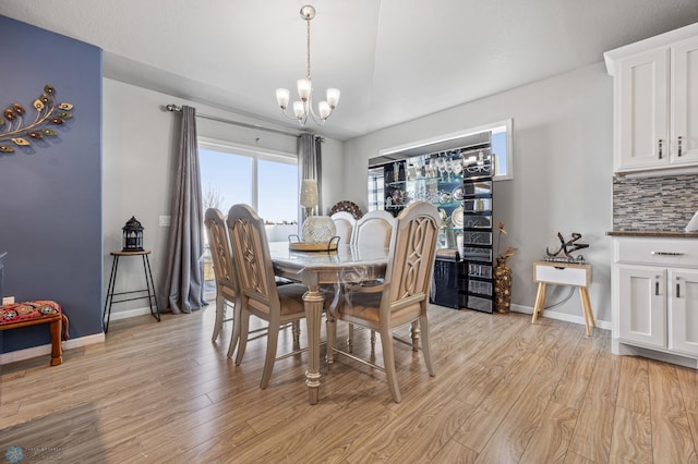 dining space with a notable chandelier and light hardwood / wood-style floors