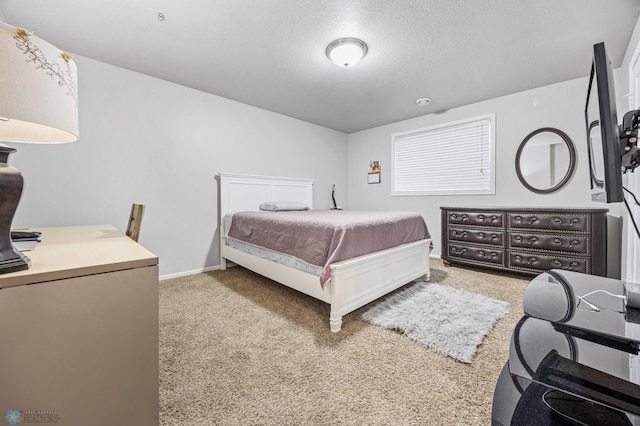 bedroom featuring light carpet and a textured ceiling