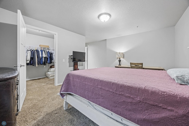 bedroom with a textured ceiling, light colored carpet, and a closet