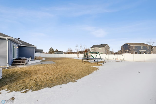 yard layered in snow with a playground