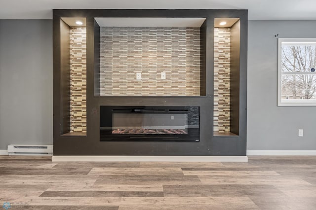 details with hardwood / wood-style floors, a large fireplace, and baseboard heating