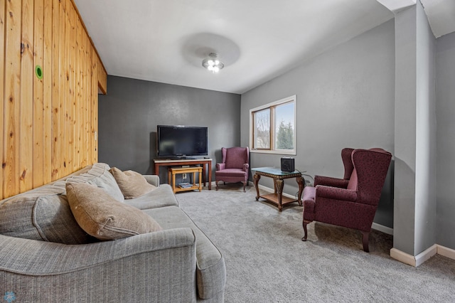 carpeted living room with wooden walls