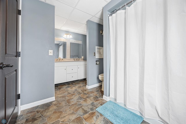 bathroom featuring vanity, a paneled ceiling, and toilet