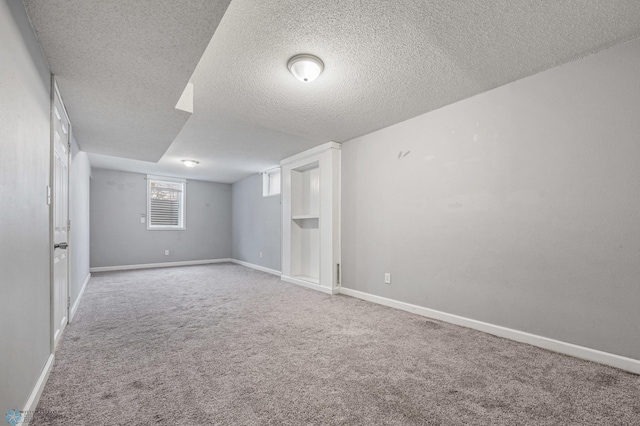 carpeted empty room featuring a textured ceiling