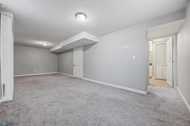 basement with light colored carpet and a textured ceiling