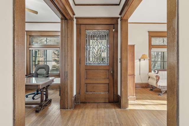 foyer featuring ornamental molding and light hardwood / wood-style floors