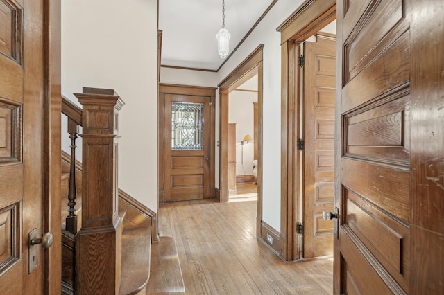 entryway with crown molding and light hardwood / wood-style flooring