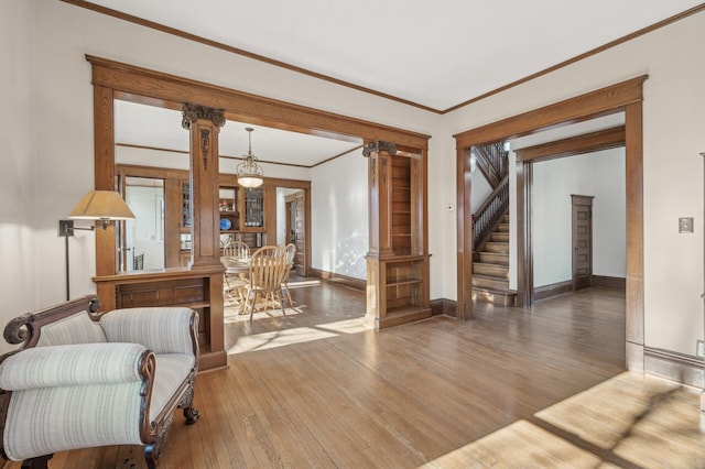 interior space with decorative columns, ornamental molding, and hardwood / wood-style floors