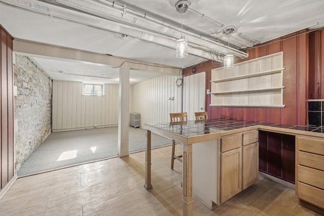 kitchen featuring hanging light fixtures, a breakfast bar area, tile counters, and kitchen peninsula