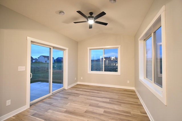 106 Fairway St, Zumbrota, MN 55992 - spare room featuring wood finished floors, lofted ceiling, a ceiling fan, baseboards, and plenty of natural light