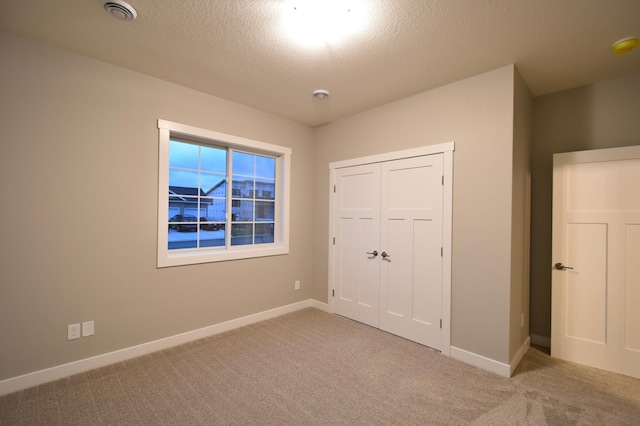 106 Fairway St, Zumbrota, MN 55992 - unfurnished bedroom featuring carpet, baseboards, a textured ceiling, and a closet