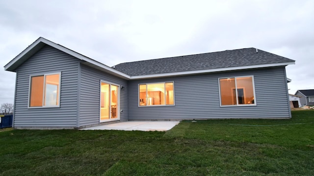106 Fairway St, Zumbrota, MN 55992 - back of property featuring a lawn, a shingled roof, and a patio area