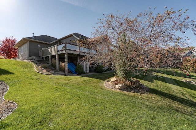 rear view of property featuring a deck and a yard