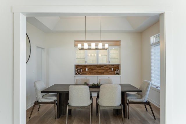 dining area featuring hardwood / wood-style floors, a tray ceiling, and a wealth of natural light