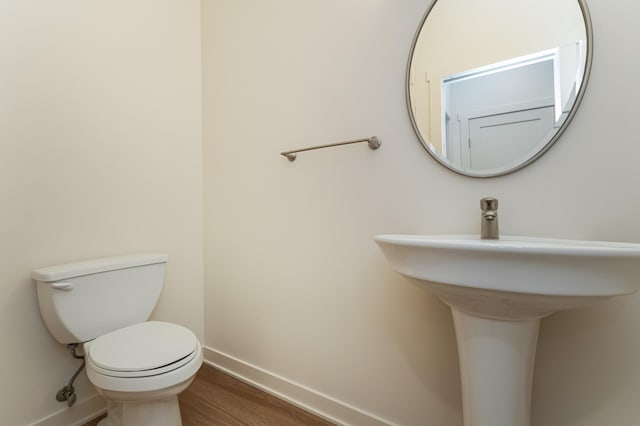 bathroom featuring hardwood / wood-style floors and toilet