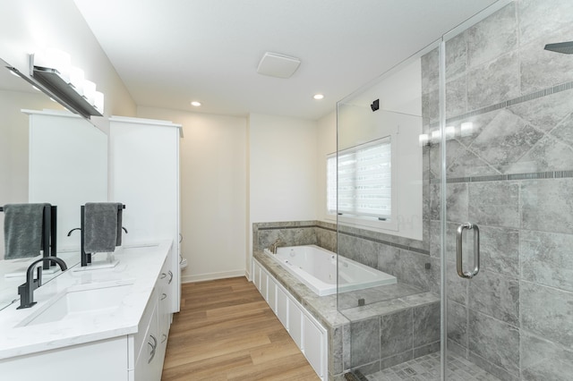 full bathroom with hardwood / wood-style flooring, vanity, separate shower and tub, and toilet