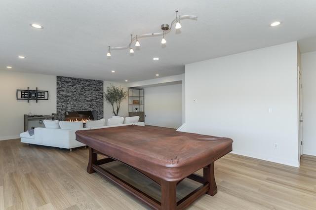 rec room featuring a fireplace, light hardwood / wood-style floors, and billiards