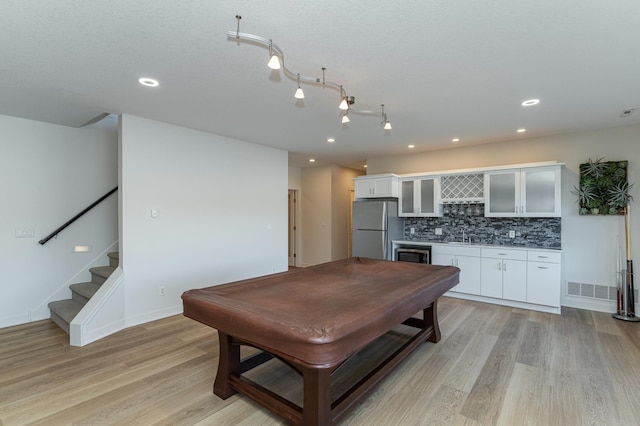 kitchen featuring white cabinetry, light hardwood / wood-style flooring, billiards, stainless steel fridge, and decorative backsplash