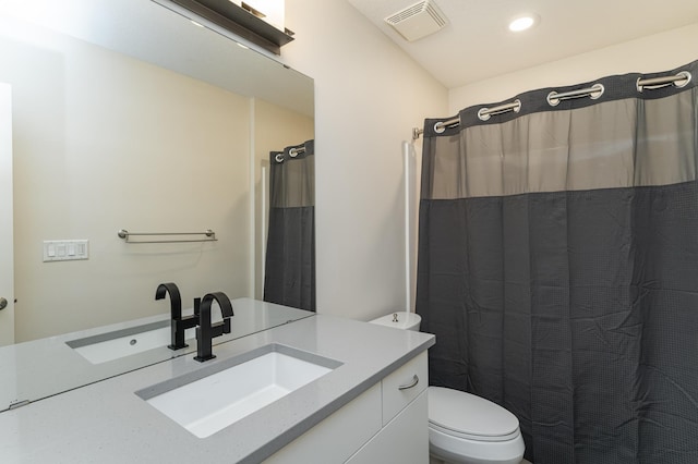 bathroom featuring vanity, toilet, and walk in shower