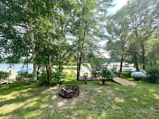 view of yard featuring a water view and an outdoor fire pit