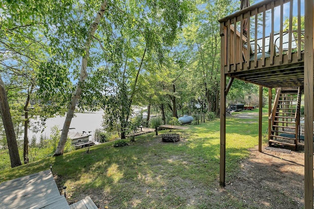 view of yard featuring a fire pit, a deck, and stairs