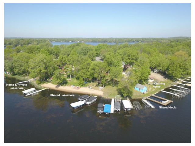 drone / aerial view featuring a wooded view and a water view