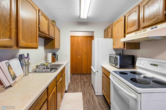 kitchen featuring a textured ceiling, dark hardwood / wood-style flooring, white appliances, and sink