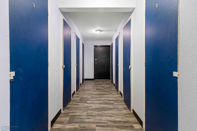 corridor featuring a textured ceiling and dark wood-type flooring