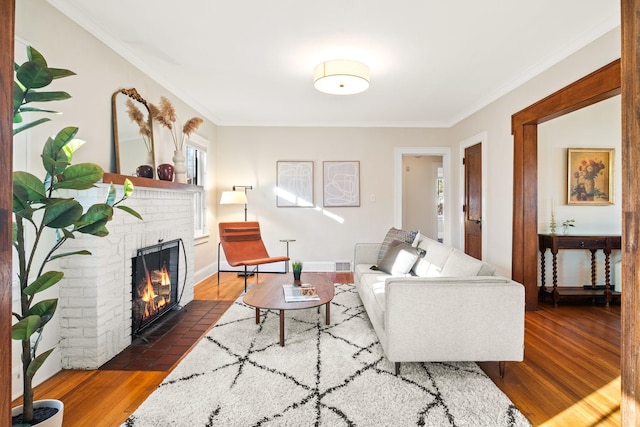 living room featuring a brick fireplace, dark wood-type flooring, and ornamental molding