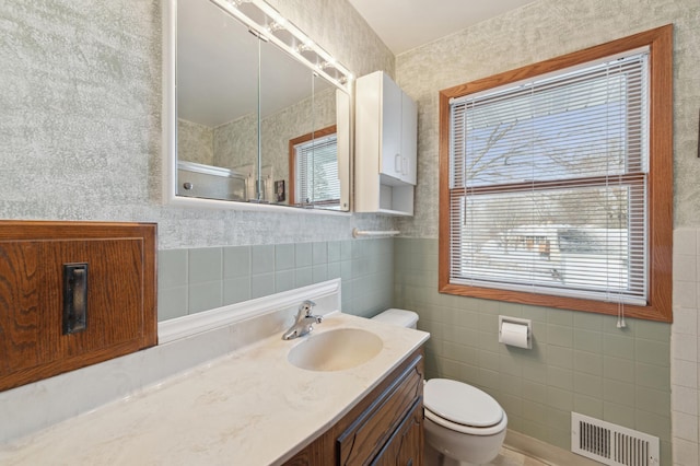 bathroom featuring vanity, a healthy amount of sunlight, tile walls, and an enclosed shower