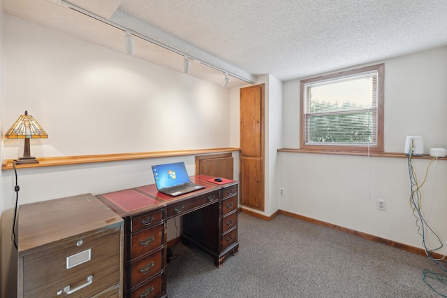 office featuring rail lighting, a textured ceiling, and dark carpet