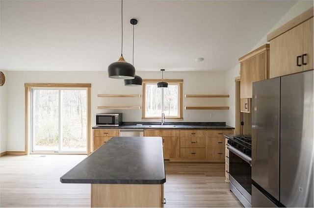 kitchen featuring a center island, a healthy amount of sunlight, hanging light fixtures, and appliances with stainless steel finishes