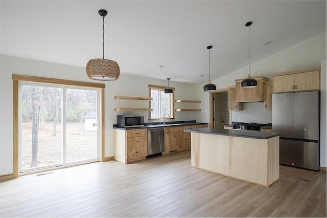 kitchen featuring light brown cabinetry, light hardwood / wood-style floors, lofted ceiling, and appliances with stainless steel finishes