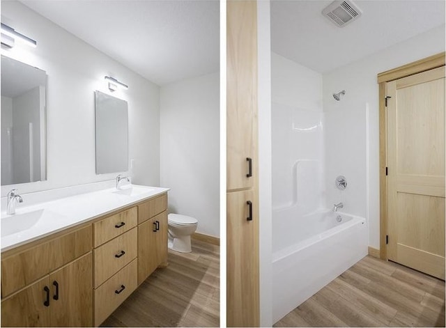 full bathroom featuring hardwood / wood-style floors, vanity, shower / bath combination, and toilet