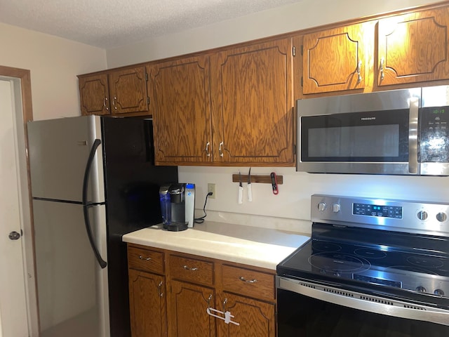 kitchen with a textured ceiling and appliances with stainless steel finishes