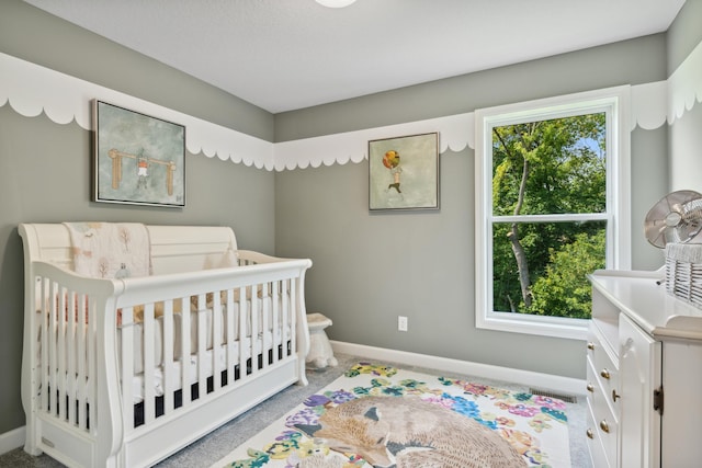 bedroom featuring a nursery area and light carpet