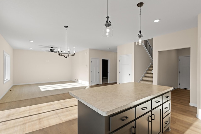 kitchen with pendant lighting, light wood-type flooring, and a kitchen island