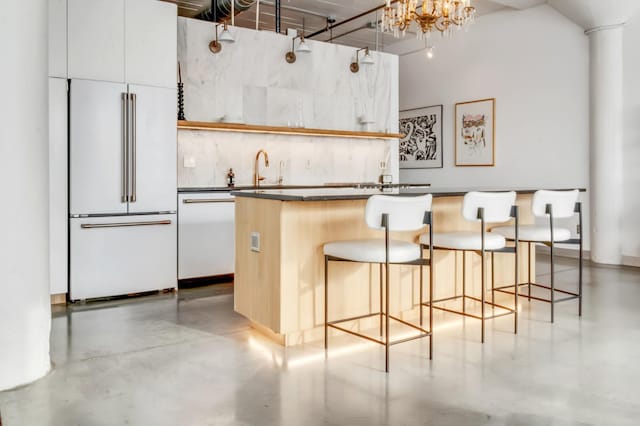 kitchen featuring a kitchen breakfast bar, a towering ceiling, white cabinets, and white appliances