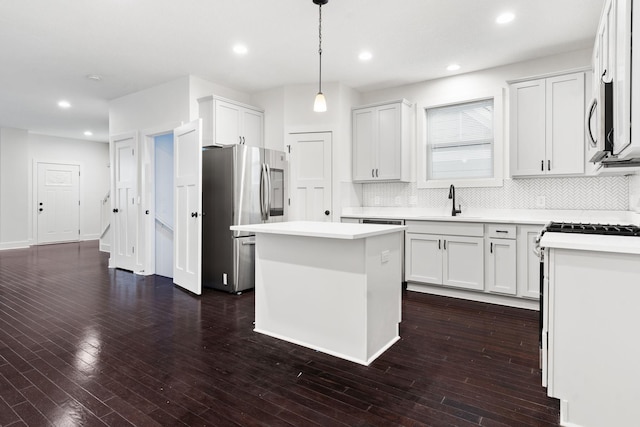 kitchen featuring stainless steel fridge, white cabinetry, a kitchen island, and hanging light fixtures