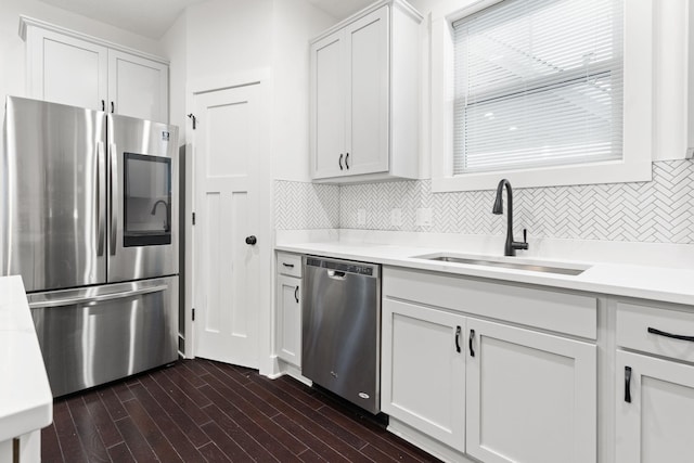 kitchen with tasteful backsplash, sink, white cabinets, and stainless steel appliances