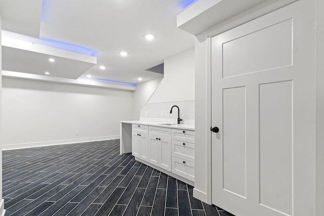 bar with white cabinetry and sink