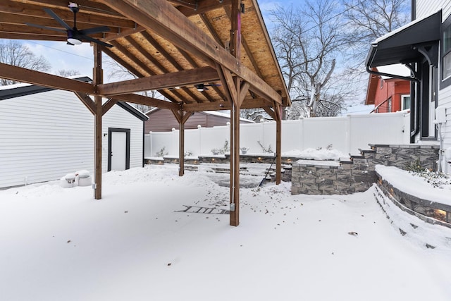 snowy yard featuring ceiling fan