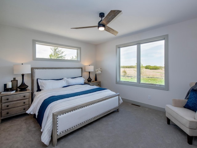 bedroom with multiple windows, ceiling fan, and carpet floors