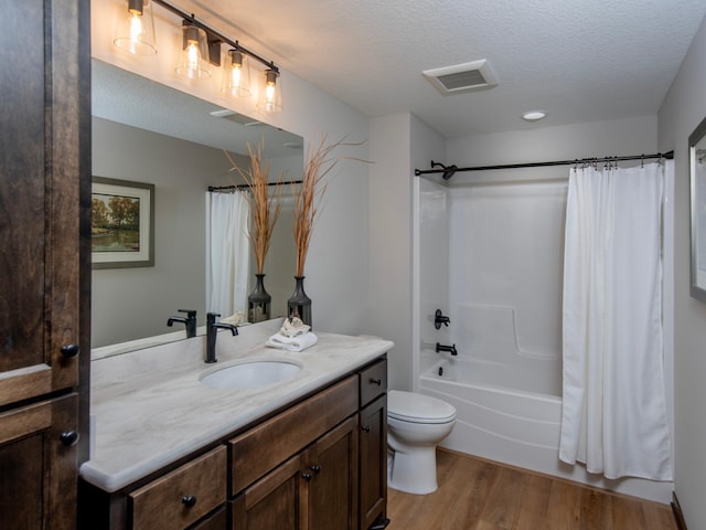 full bathroom with shower / bath combo with shower curtain, vanity, wood-type flooring, and a textured ceiling