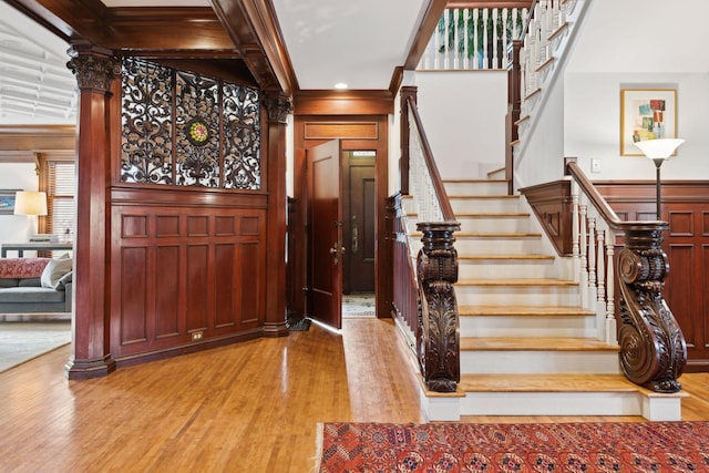 stairway featuring beam ceiling, hardwood / wood-style floors, coffered ceiling, and ornamental molding