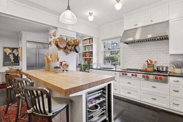 kitchen with white cabinets, wood counters, sink, and stainless steel appliances