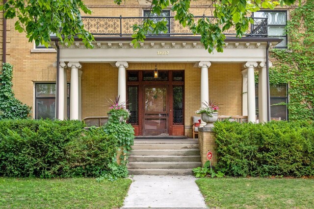 1807 Dupont Ave S, Minneapolis, MN 55403 - doorway to property featuring brick siding, covered porch, and a balcony