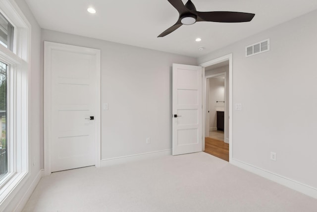 unfurnished bedroom with ceiling fan and light carpet